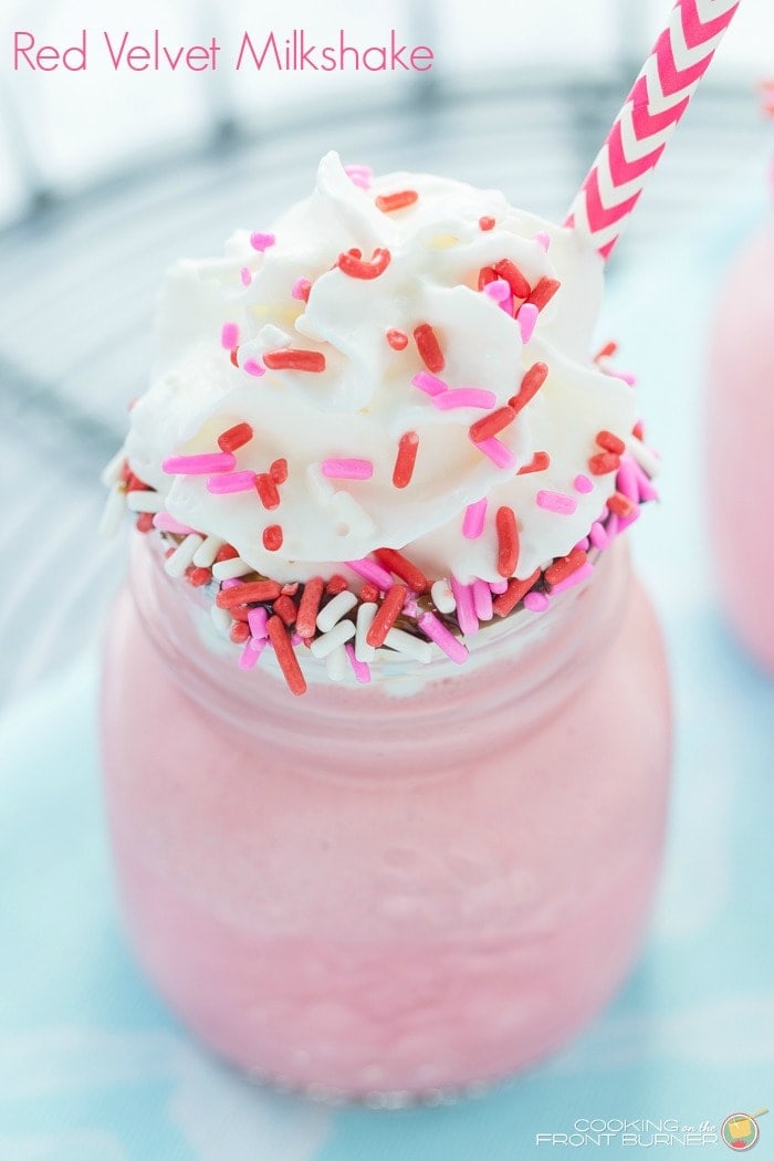 This Red Velvet Milkshake recipe is fun to make and will be perfect for Valentine's Day! This is a delicious shake made with vanilla ice cream, red velvet cake mix, vanilla, milk, hot fudge sauce, and topped with cool whip and sprinkles!!