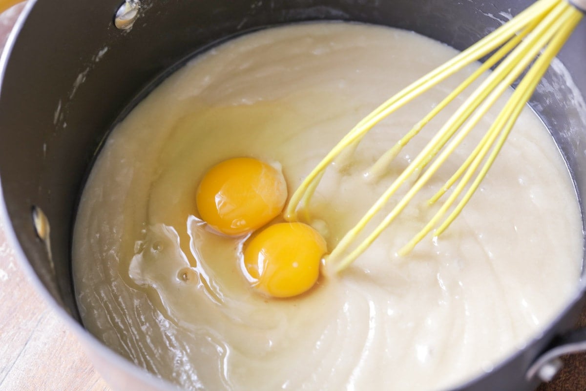 Easy Cake Recipes - image of mixing eggs into cake batter with a whisk.