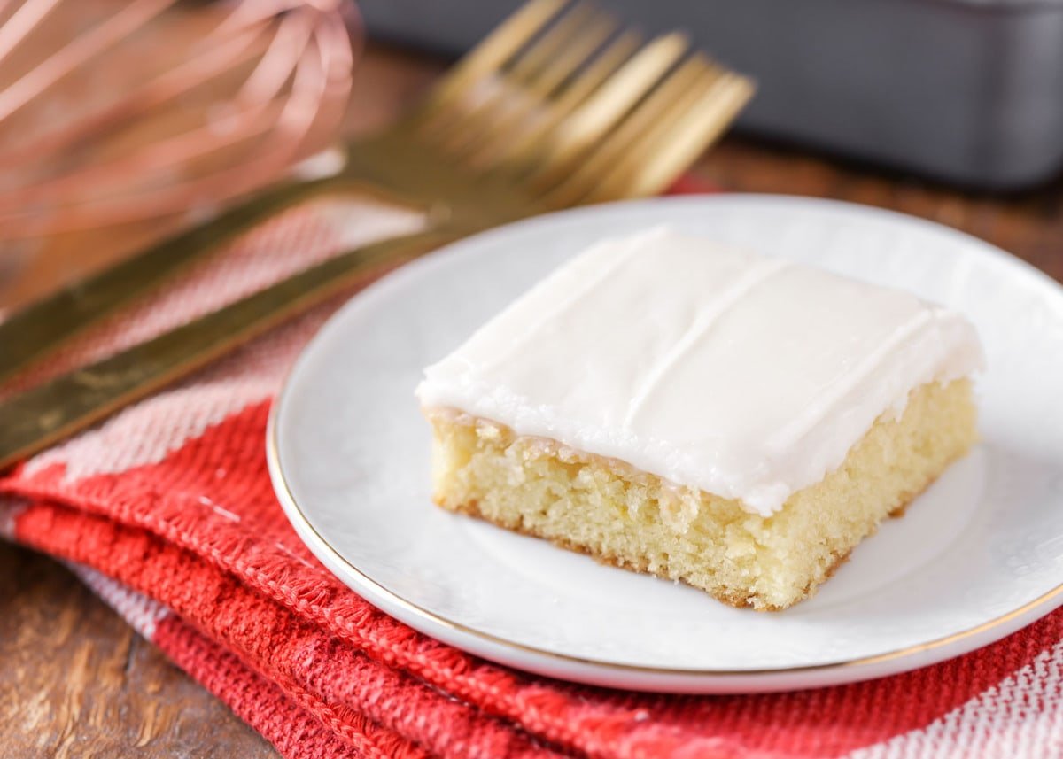 Slice of white texas sheet cake on a white plate