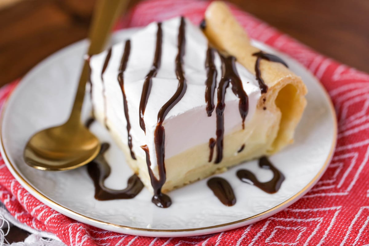New years eve desserts - a square slice of cream puff cake recipe drizzled with chocolate sauce.