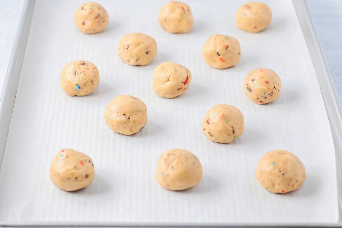 Cookie dough scooped into balls on cookie sheet.