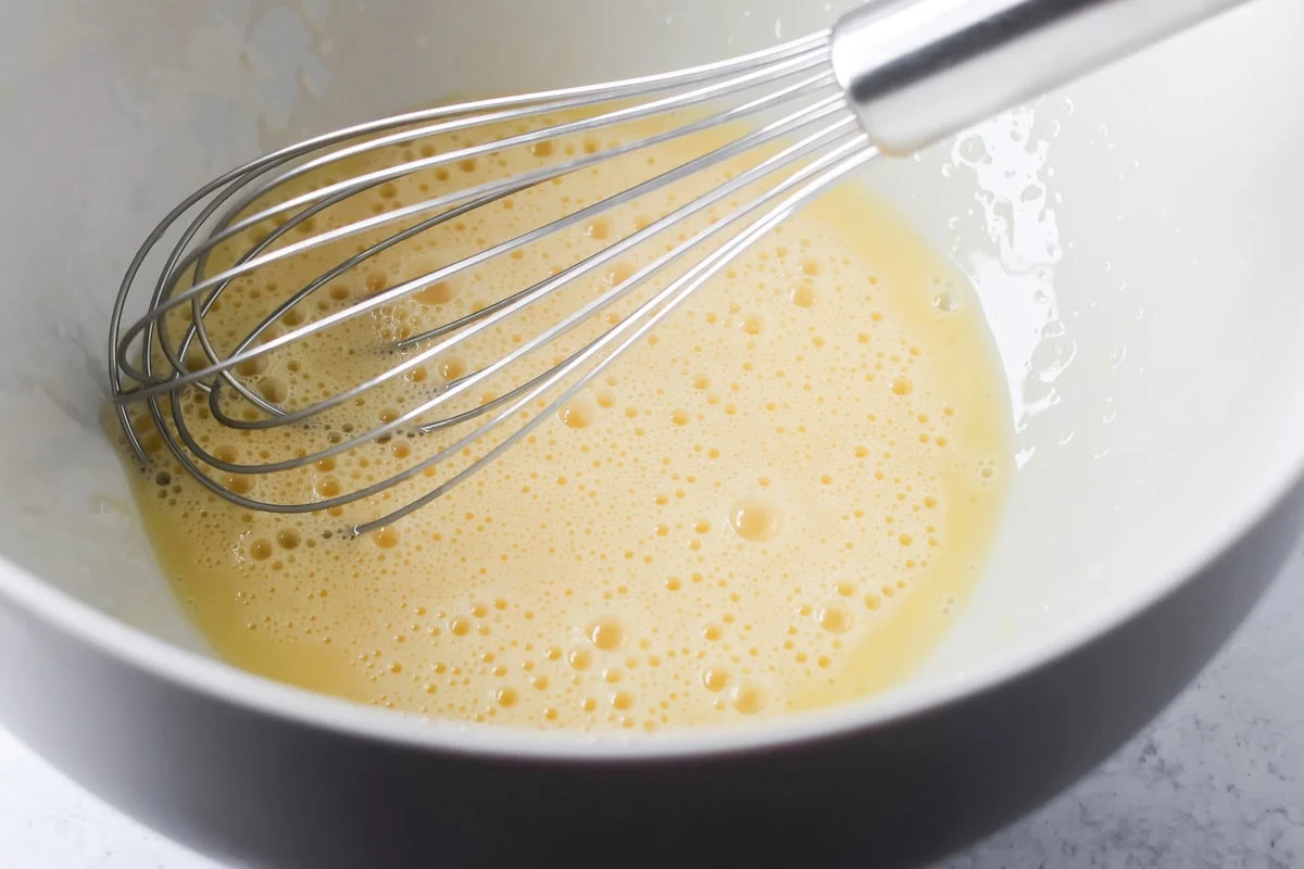 Eggs and milk mixed in mixing bowl.