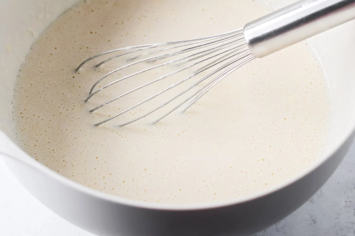 Swedish pancakes batter mixed together in mixing bowl.