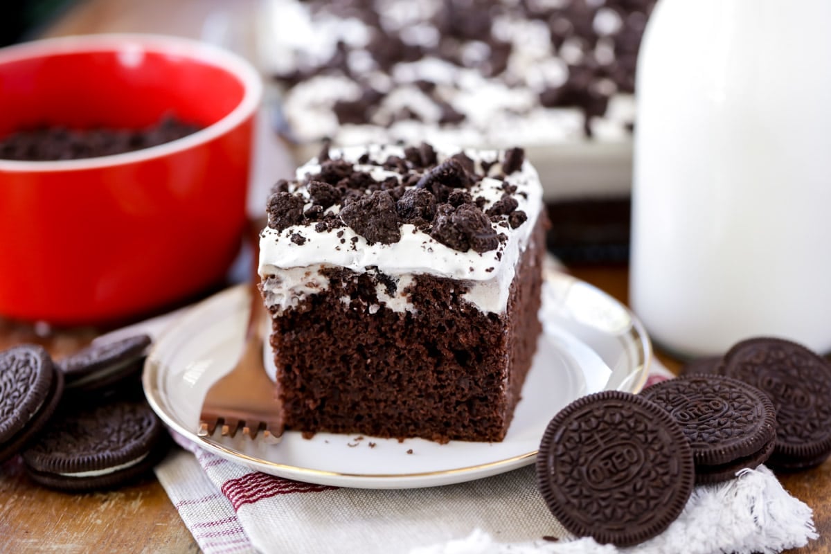 Chocolate Cake Recipes - A slice of oreo pudding poke cake on a white plate.