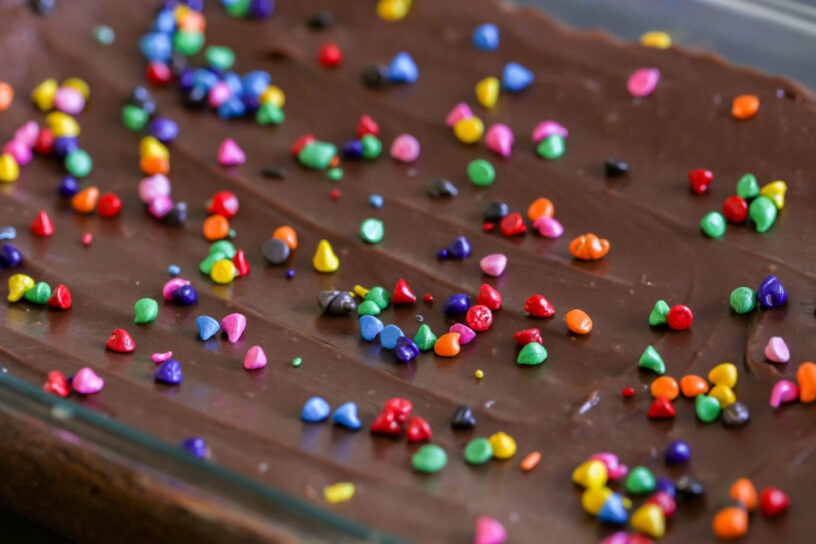 Close up image of frosted brownies with sprinkles on top.