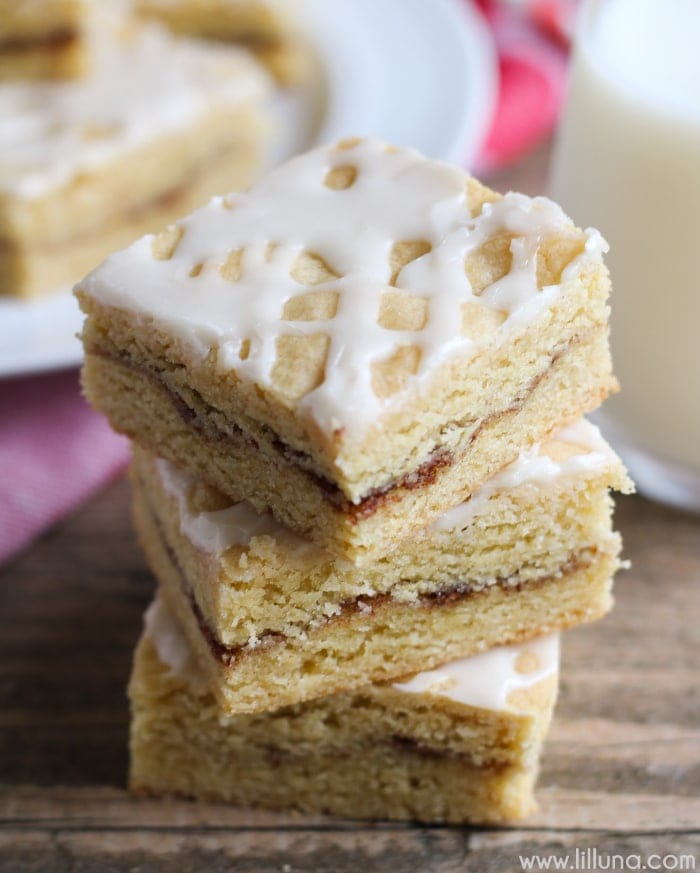Christmas desserts - snickerdoodle bars with glaze, stacked on a table.
