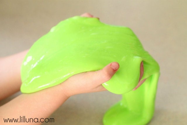 Two hands holding green gak slime