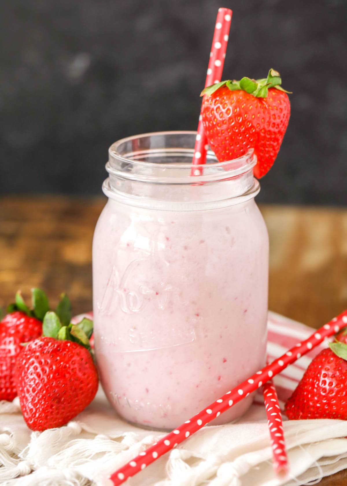 Strawberry garnished mason jar filled with pudding milkshake