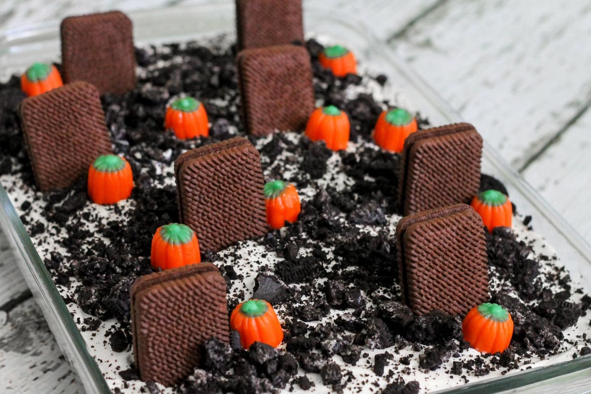 Halloween dirt cake topped with mallow pumpkins in a glass baking dish