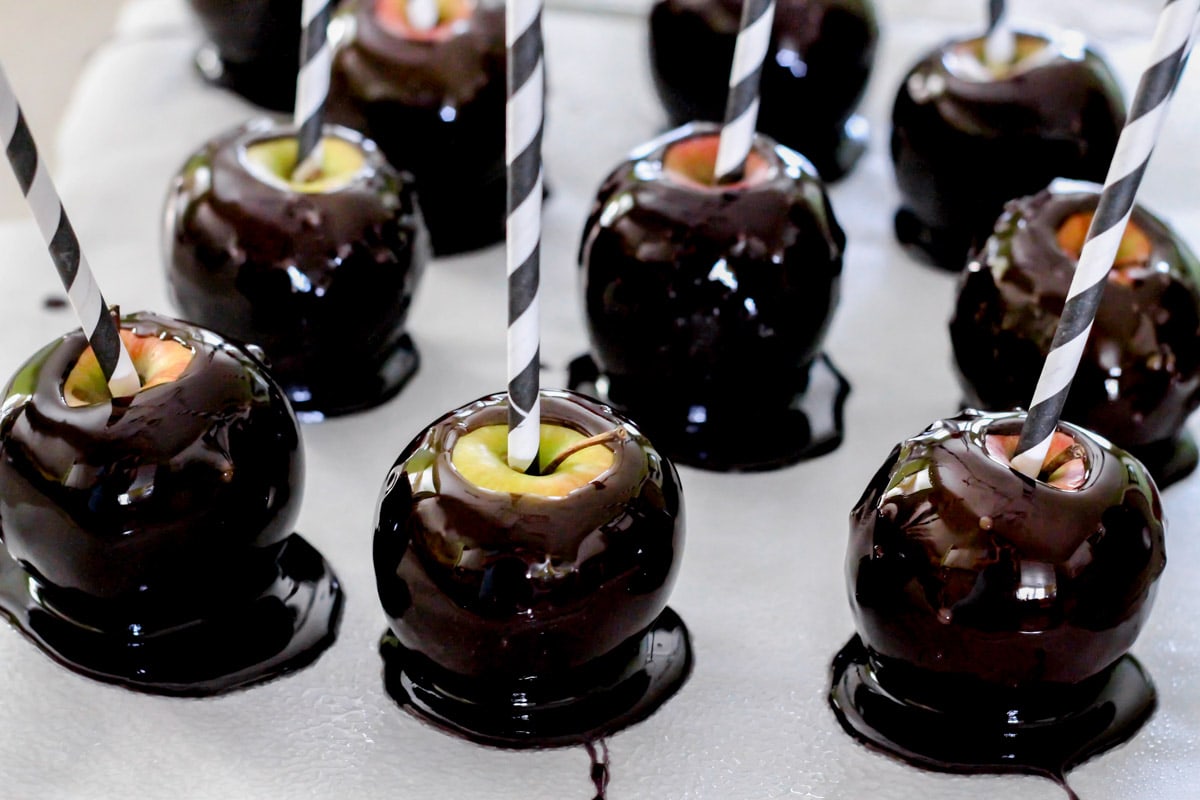 Halloween dinner ideas - black candy apples lined up on wax paper.