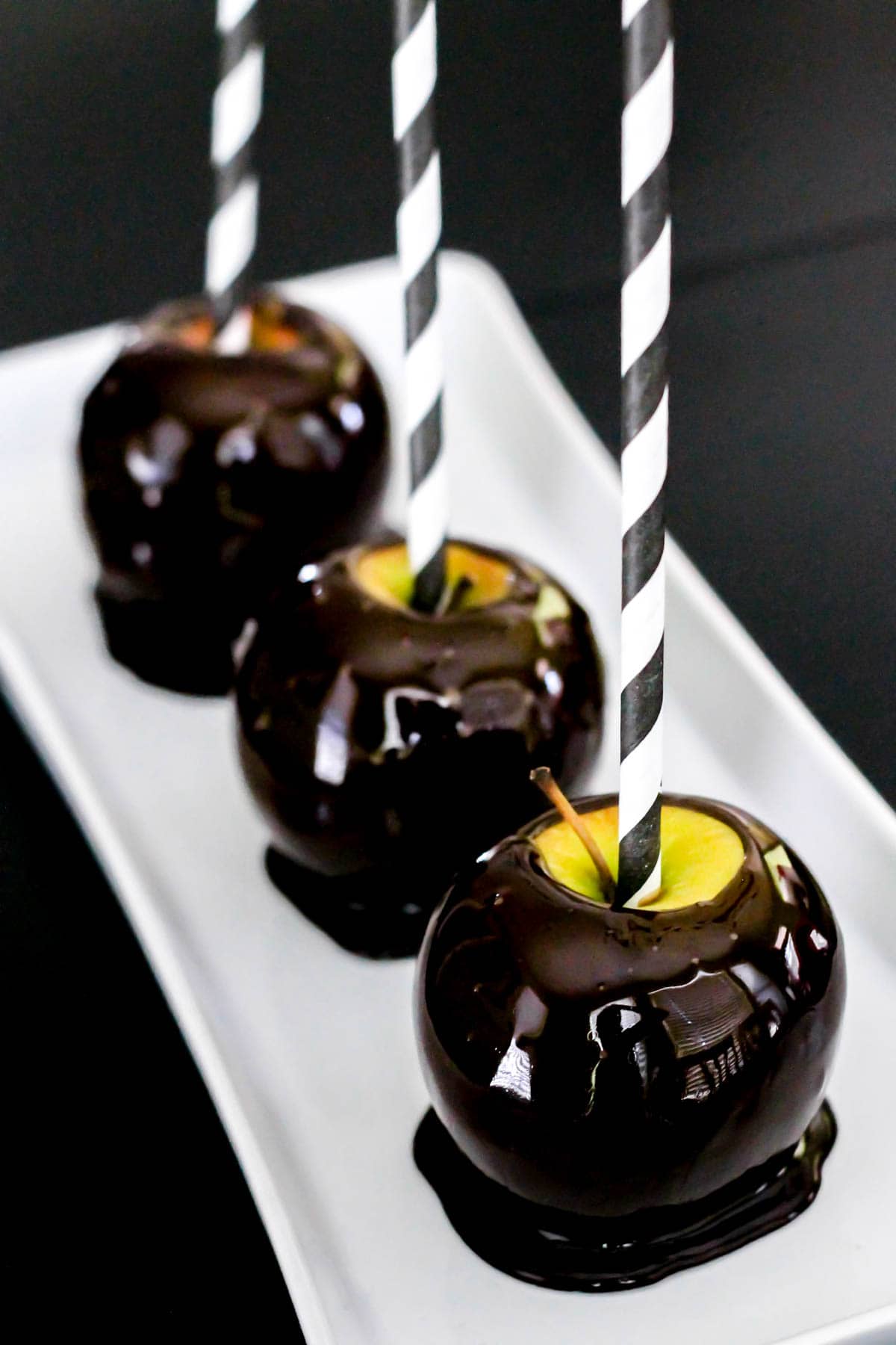 blackout candy apples on a white plate