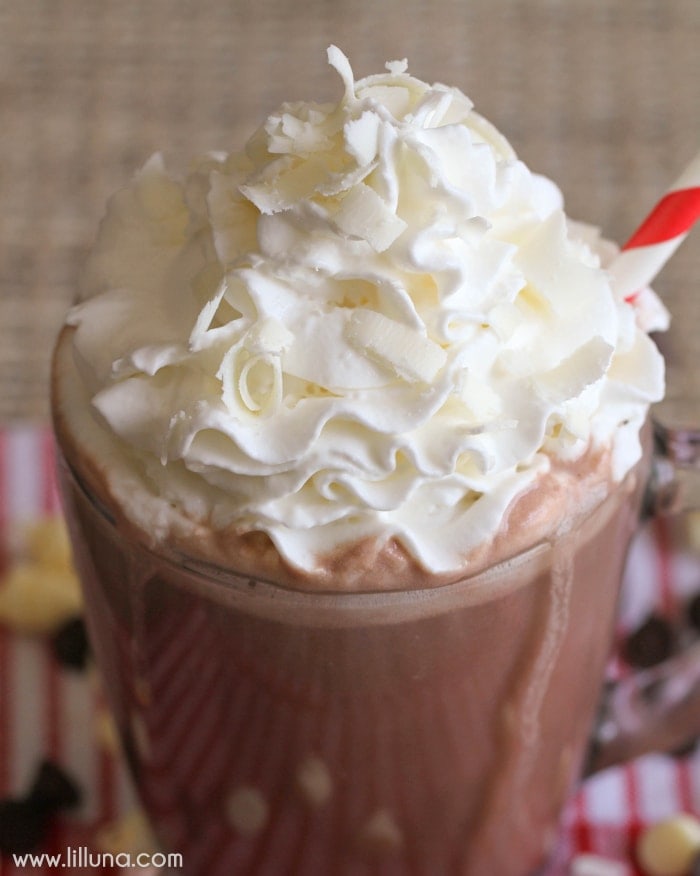 Hot cocoa topped with whipped cream and a straw