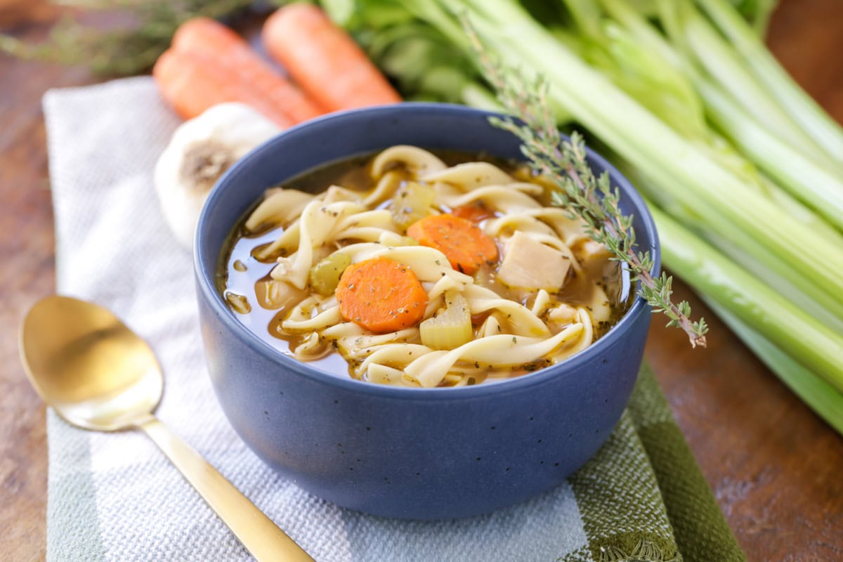 Homemade chicken noodle soup in blue bowl.