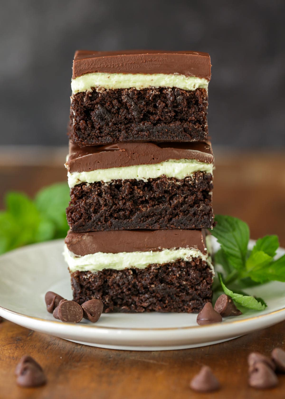 Mint brownies stacked on top of each other on white plate.