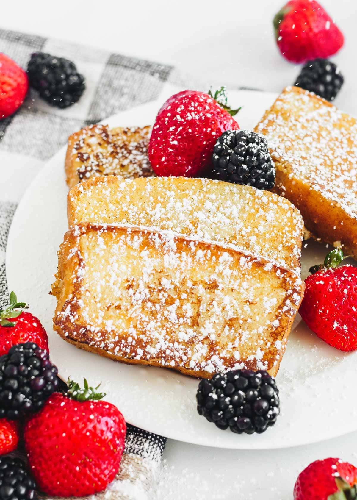 Pound cake french toast recipe on a white plate with berries