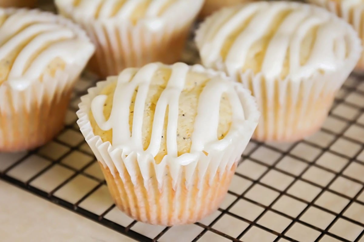 Poppy Seed Muffins on a cooling rack, topped with glaze