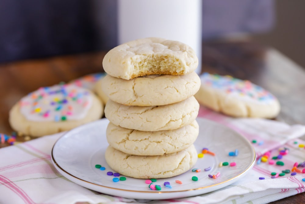 A stack of chewy sugar cookies on a white plate