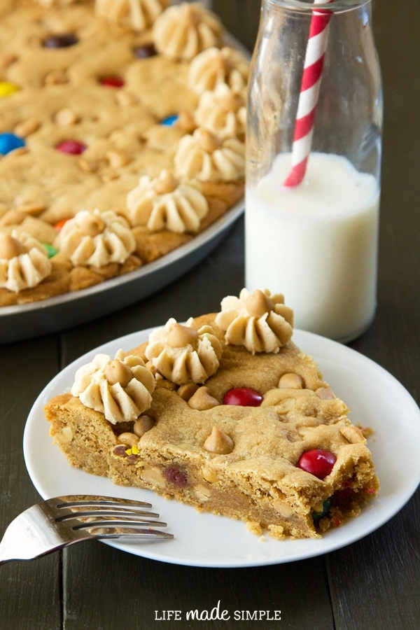 a slice of Peanut Butter Cookie Cake on a white plate with a bite missing