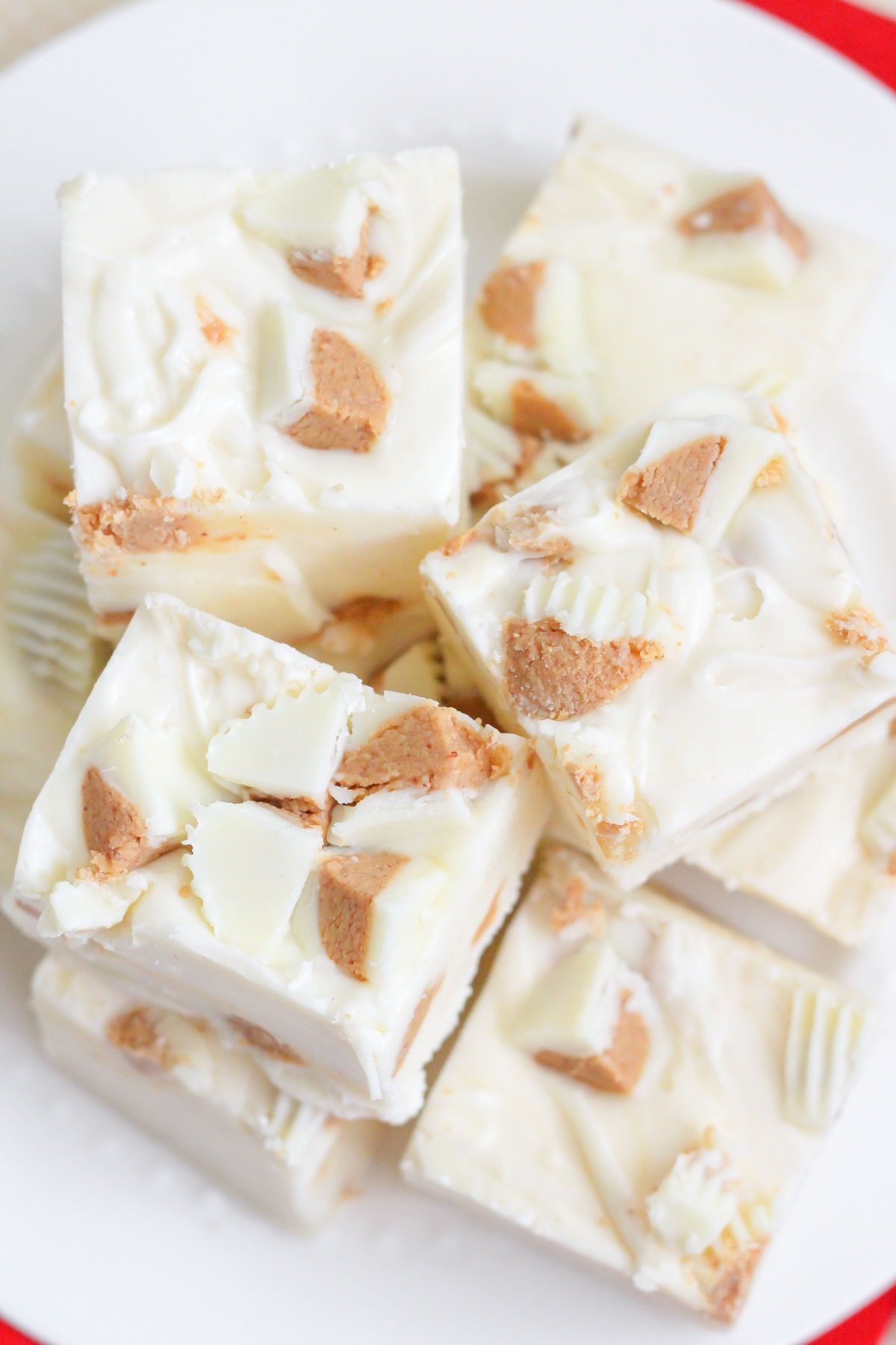 White chocolate Reeses fudge cut and stacked on a white plate