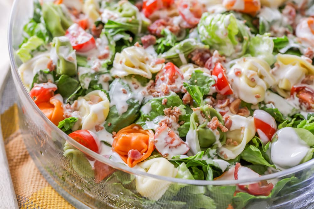 Close up of tortellini salad in a glass dish. 