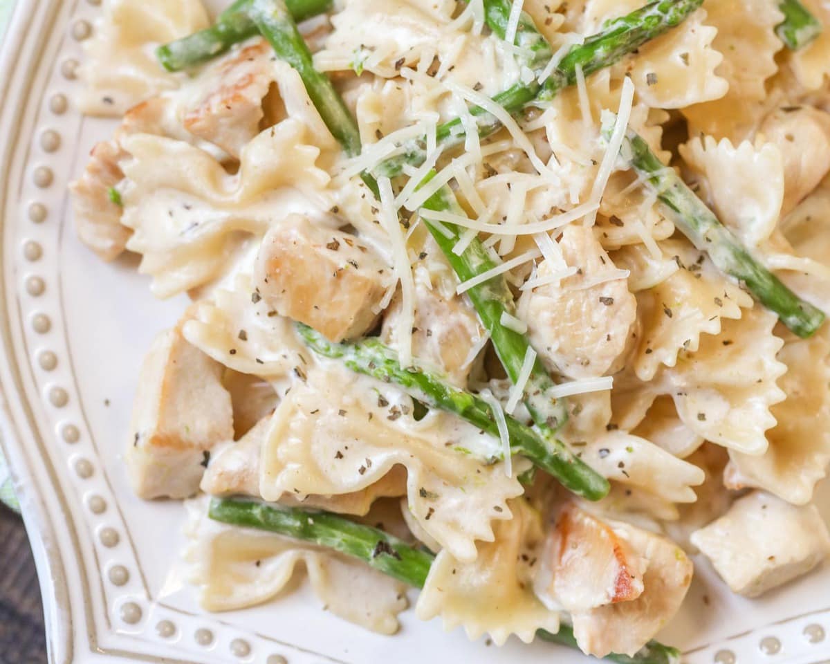 Chicken Pasta Recipes - Chicken and asparagus pasta on a decorative white plate.