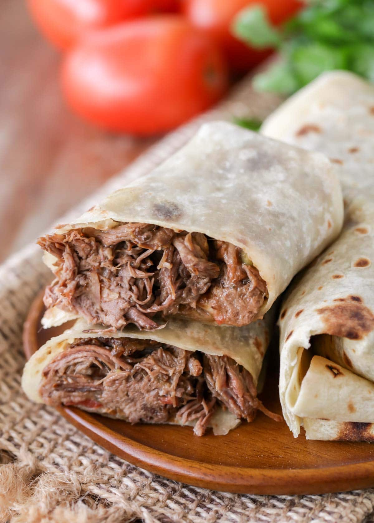 Green chile burritos sliced in half and stacked on a plate.