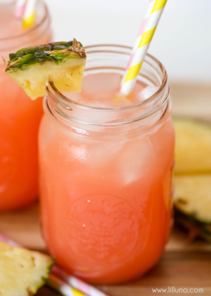 Valentines Dinner Ideas - Pineapple Pink Lemonade Soda in a Mason jar garnished with pineapple and a yellow and white striped straw. 