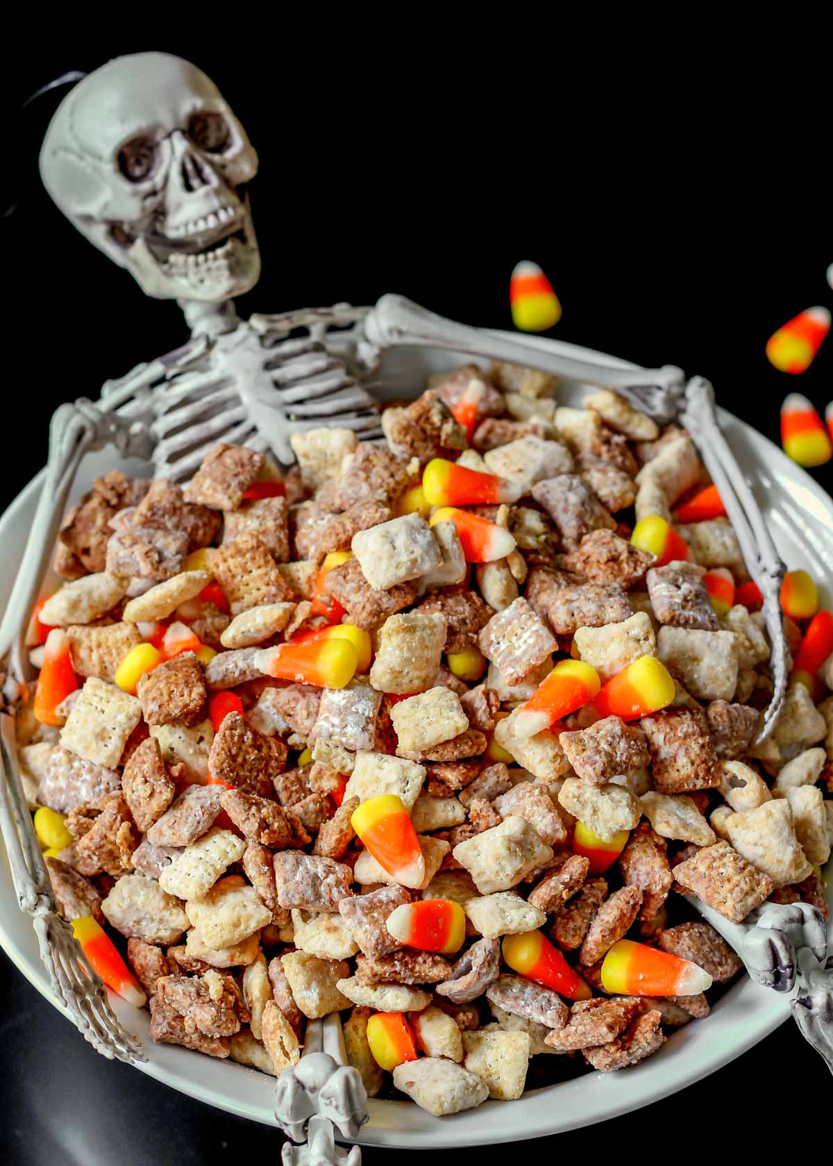 Halloween puppy chow in a white bowl with a skeleton