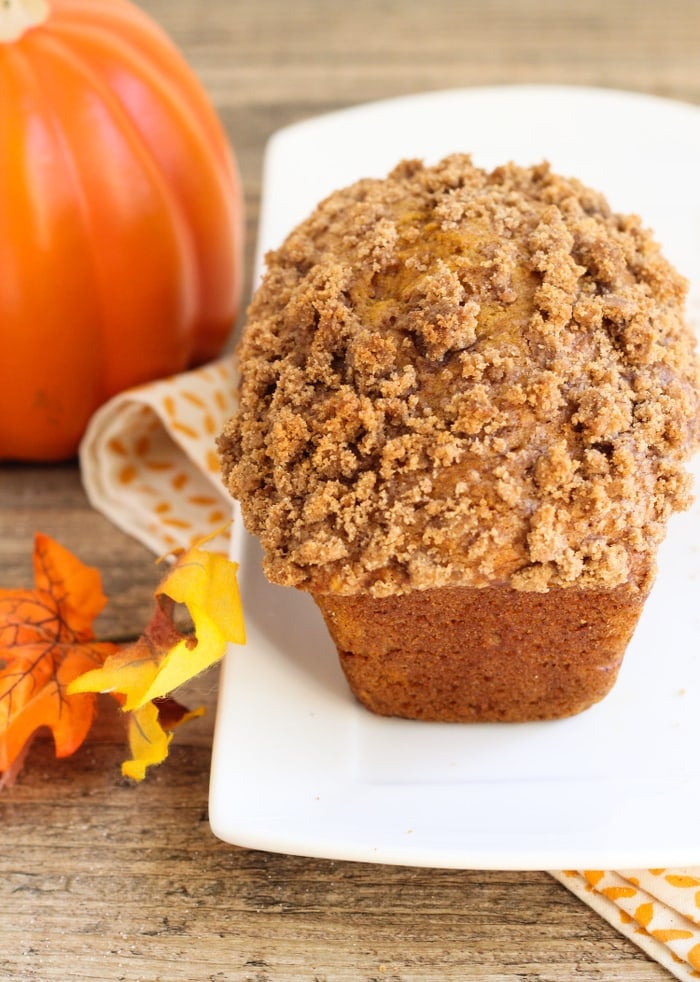 loaf of pumpkin streusel bread on a white plate