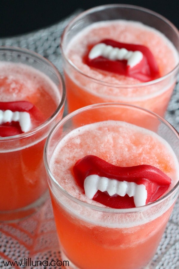 Halloween Slushy Punch Oppskrift Med Voks Lepper på { lilluna.com } Ingredienser inkluderer jordbær jello, ananasjuice, appelsinjuice, sitron lime brus!