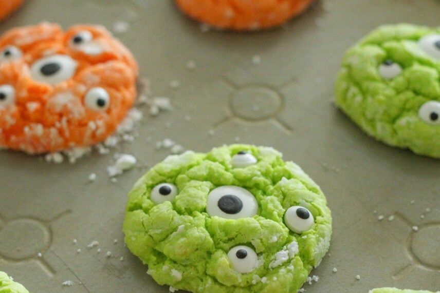 Fun, bright and festive cake mix cookies are all dressed up to look like monsters. Gooey monster cookies are great all year long!! Gooey monster cookies on a sheet pan.