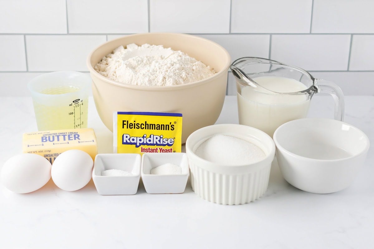 Our dinner rolls recipe delivers a soft, buttery best-loved recipe, perfect for holidays or any occasion and impossible to resist. Homemade dinner rolls recipe ingredients on counter.