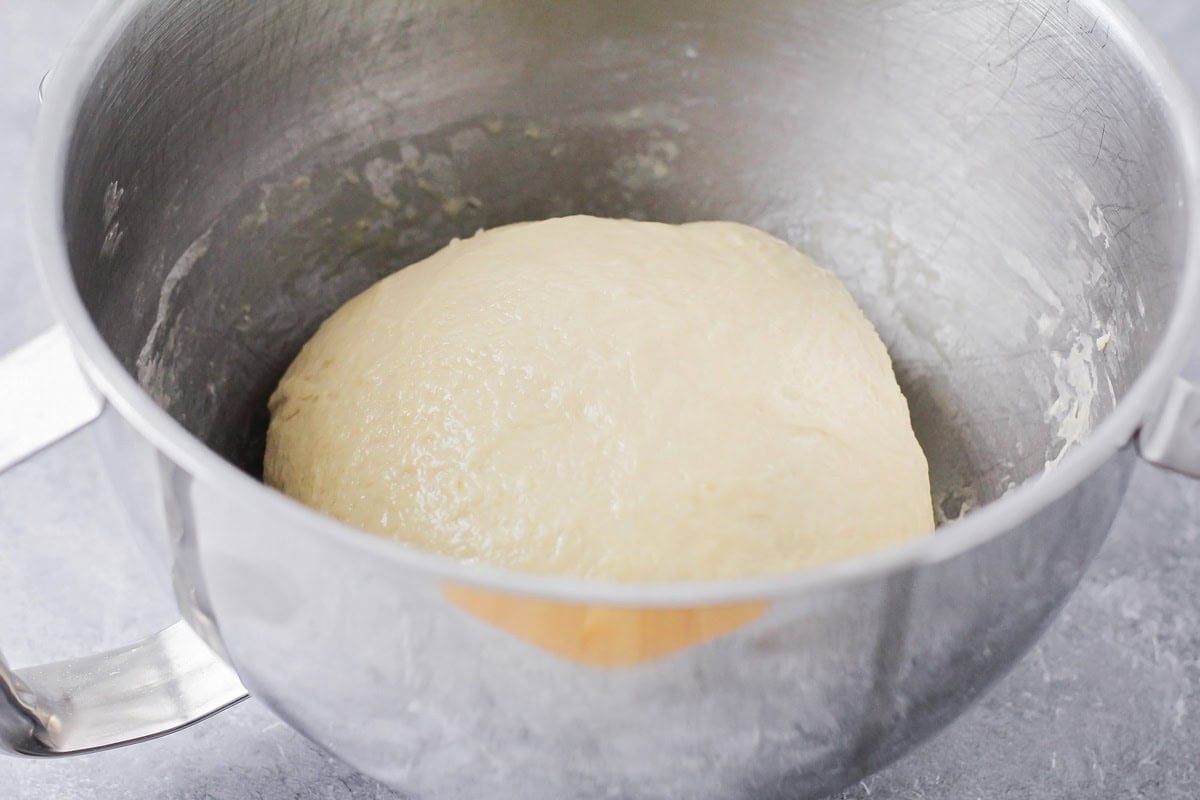 Yeast dinner rolls dough rising in large bowl.