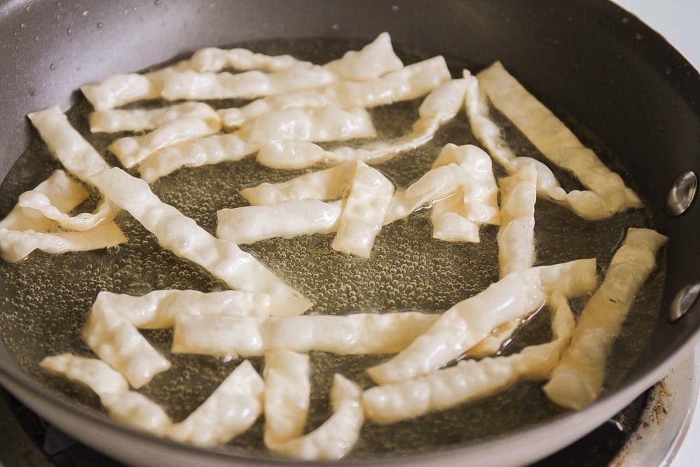 Making homemade fried wontons to put in Chinese pasta salad recipe