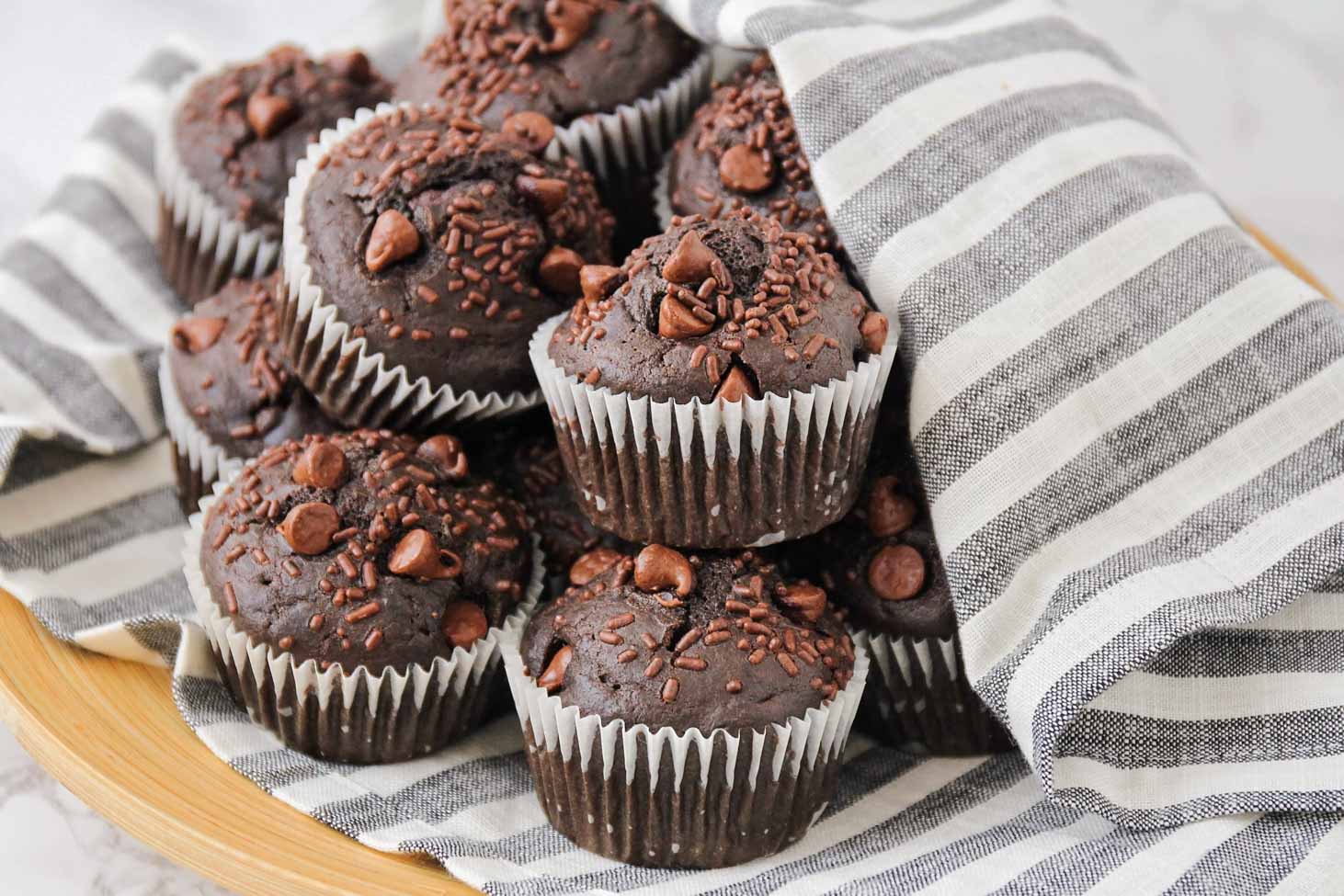 Chocolate Muffins on top of a striped dish towel.