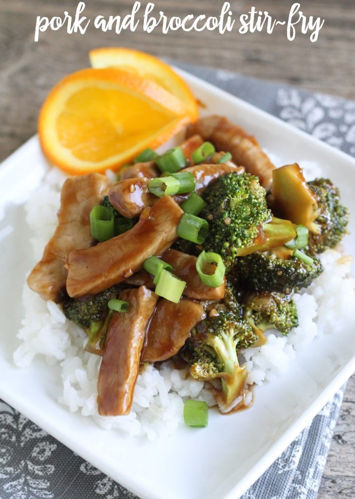 roerbak van varkensvlees en broccoli, geserveerd met witte rijst en groene uien.