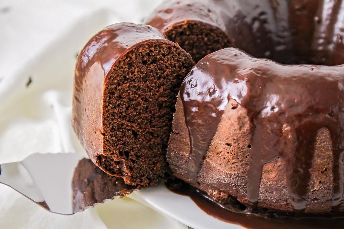 Chocolate bunt cake with a slice on a cake server.