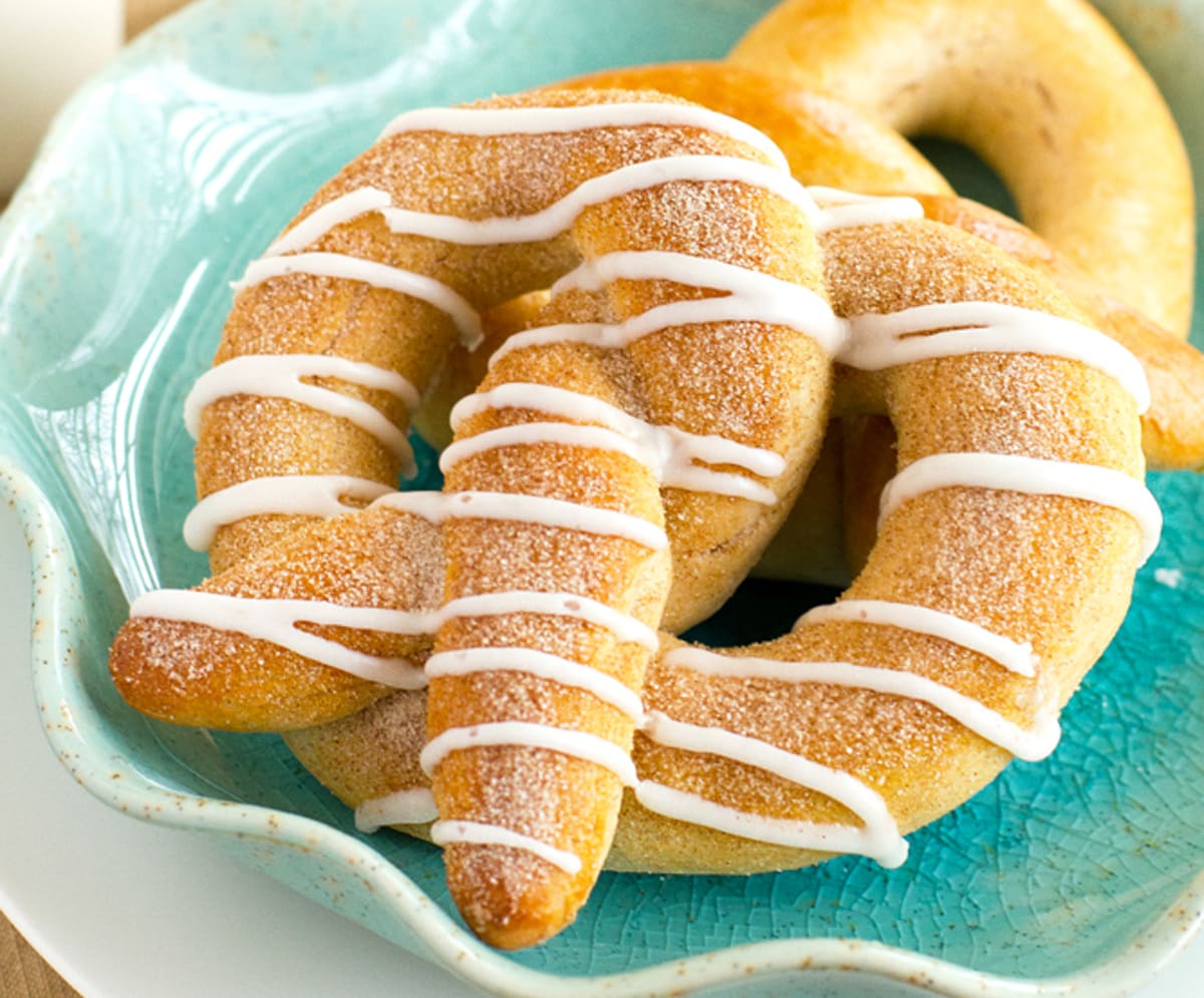 cinnamon pretzel with drizzled glaze on a blue plate