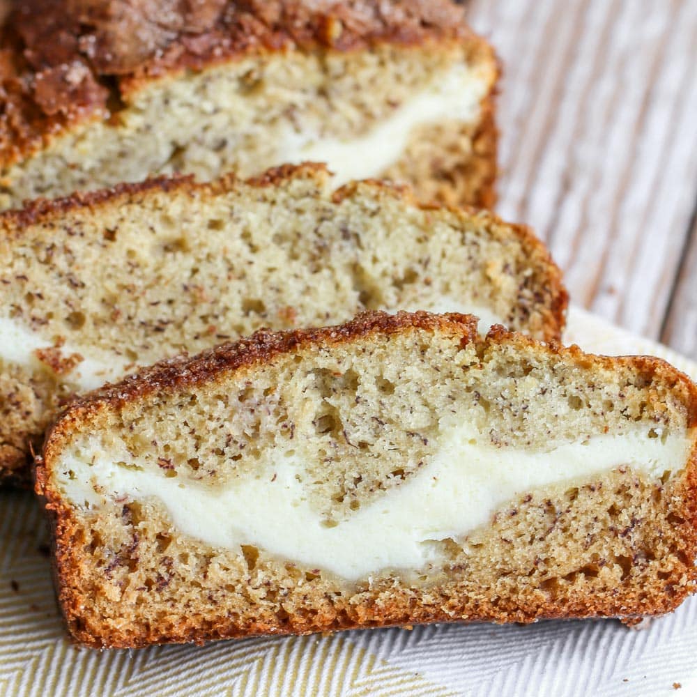 Cream cheese banana bread sliced and served on a towel.