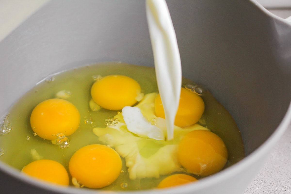 Eggs and milk being mixed in mixing bowl.