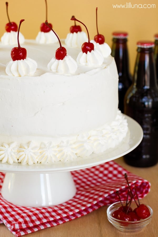 Whipped cream covered cake on a white platter