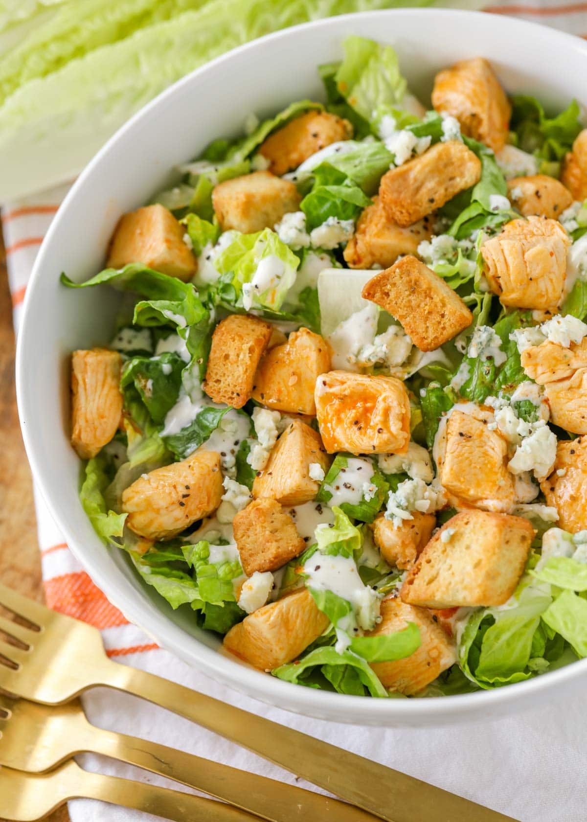 chicken buffalo salad in a white bowl topped with croutons