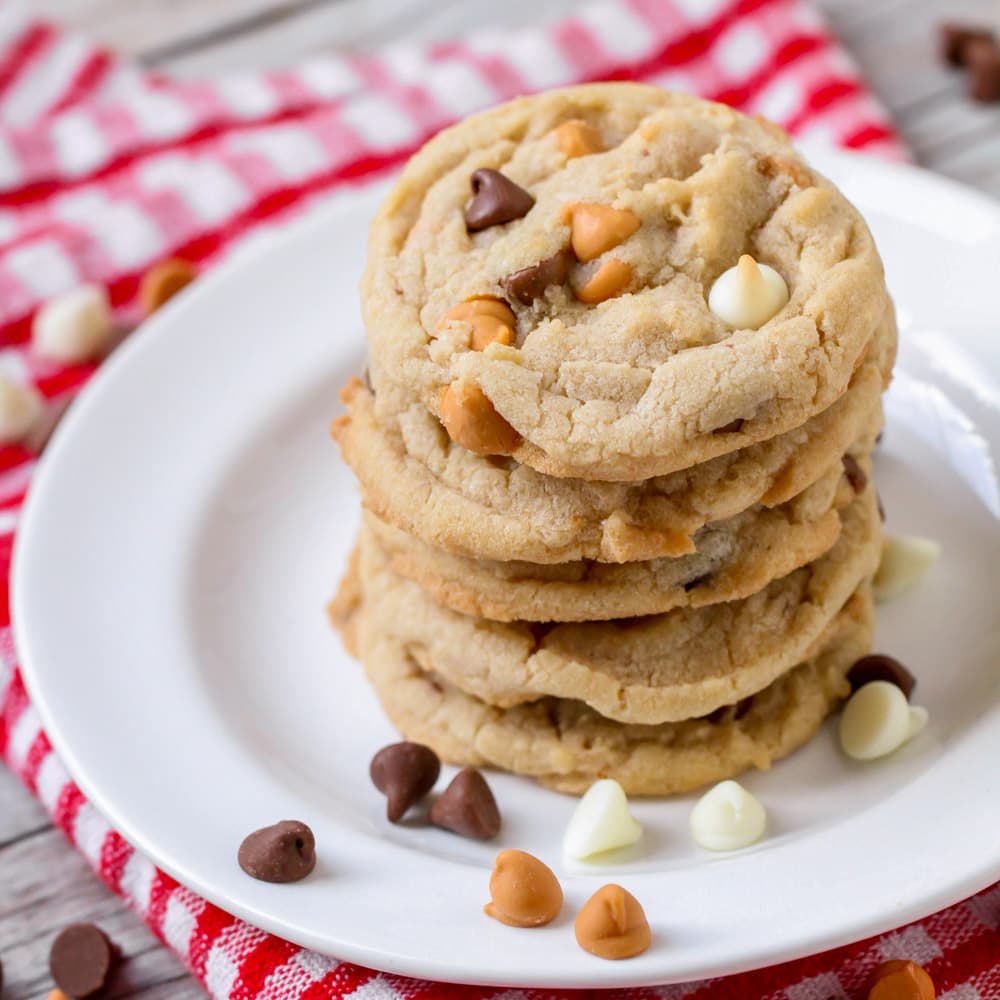 A stack of triple chocolate cookies on a white plate