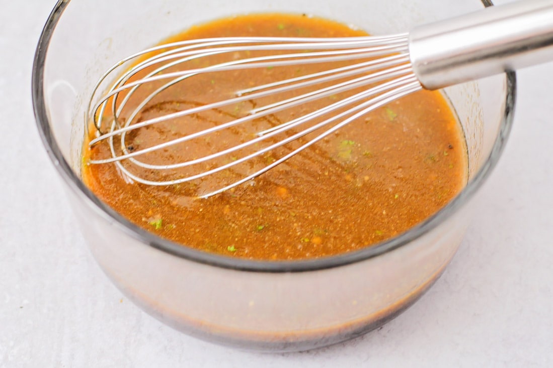 Marinade ingredients whisked together in a glass bowl.