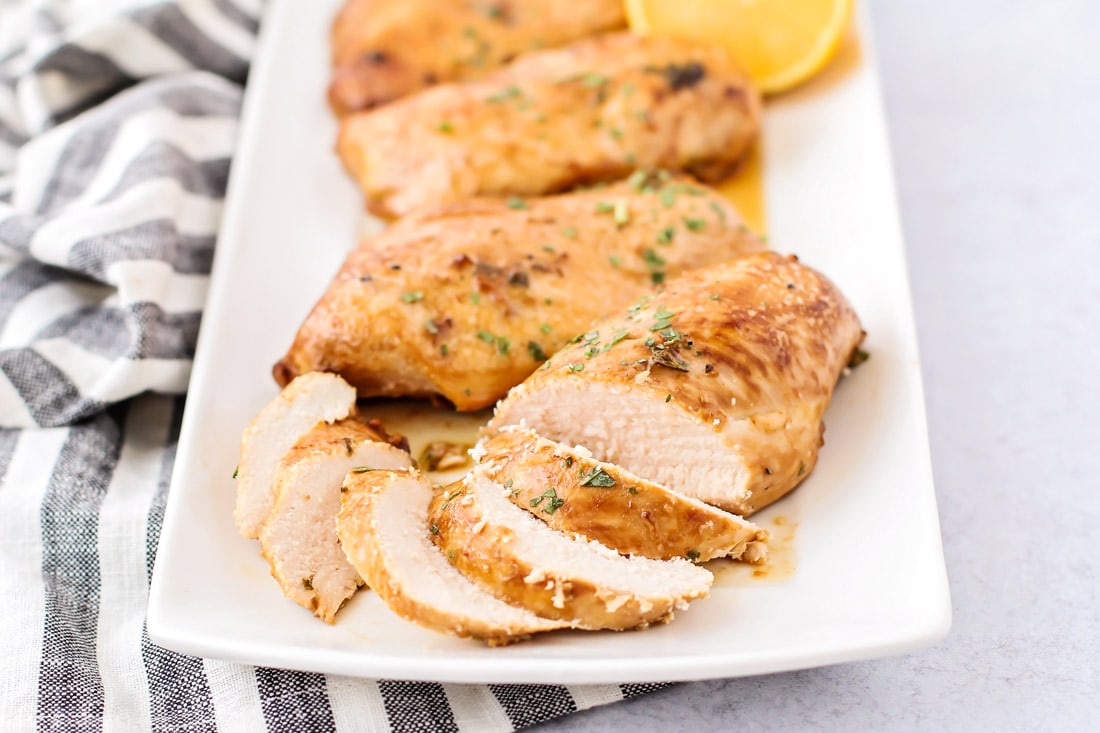 Summer Recipes - Marinated chicken cut into slices on a white serving platter.