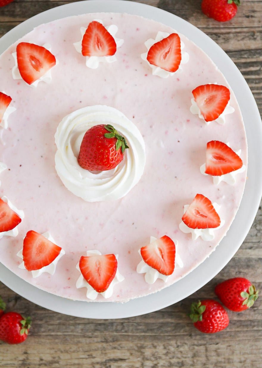 Easy frozen strawberry dessert served on a white plate and topped with fresh strawberries.
