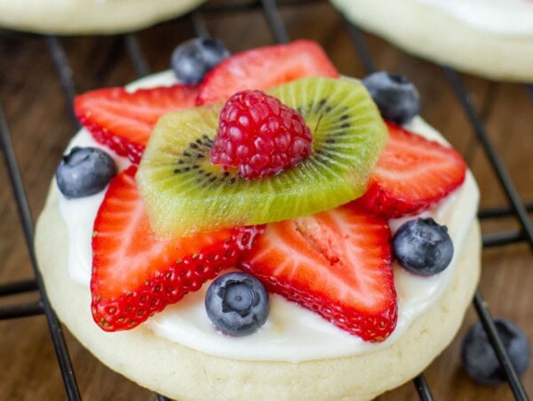 Fresh fruit pizza cookies on a cooling rack.