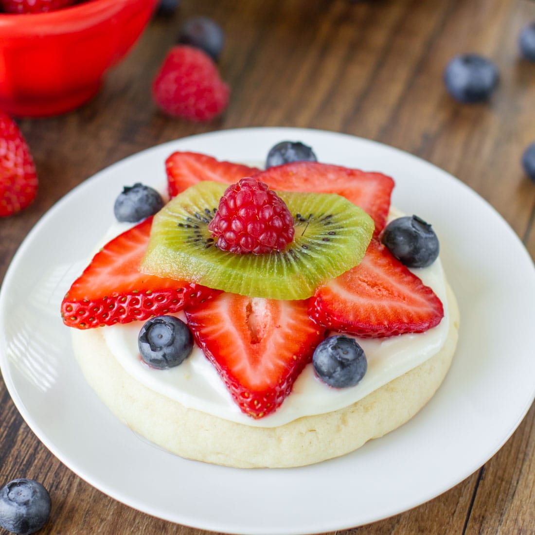 Fruit Pizza Cookies topped with fresh fruit on a white plate.