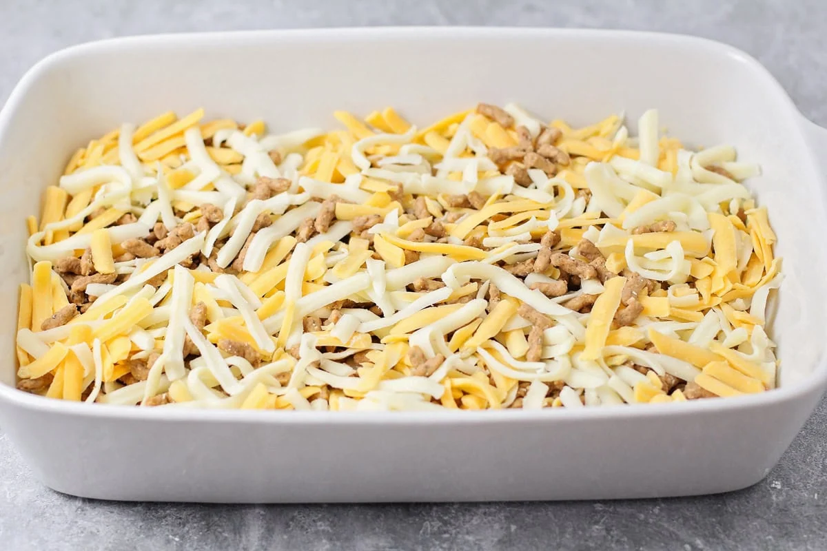 Sausage and cheese poured over biscuits for breakfast casserole.