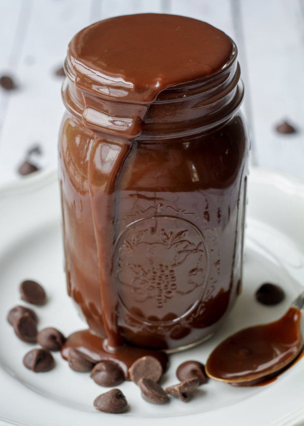 Our favorite hot fudge sauce recipe oozing from a mason jar.